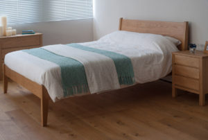 A taller classic wooden bed the Zanskar here made in Oak