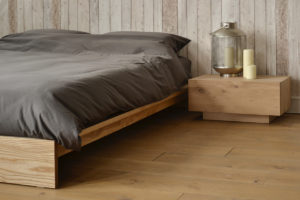 Angled view of our solid wood Ki Bed frame shown with Ethnicraft Madra table as bedside