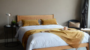 Warm autumn shades with mustard yellow and a cherry wood Camden bed