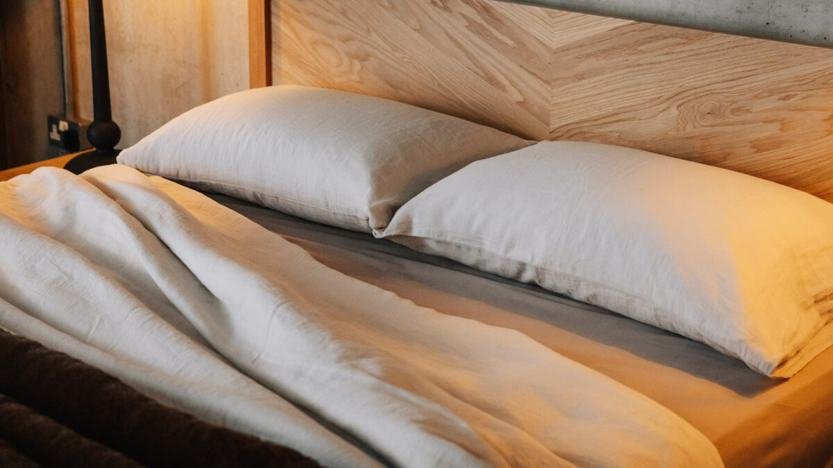 linen bedding on Kelham oak bed showing the hand crafted chevron pattern to the headboard