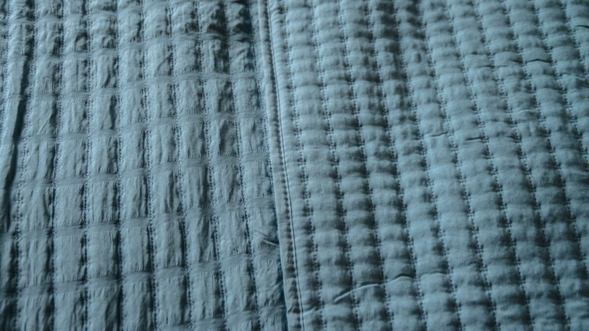 blue quilted bedspread surface pattern detail