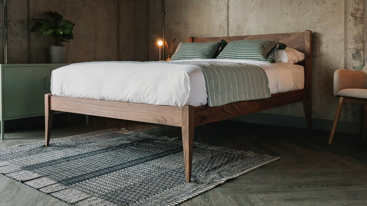 a solid walnut classic bed with elegant tapered legs