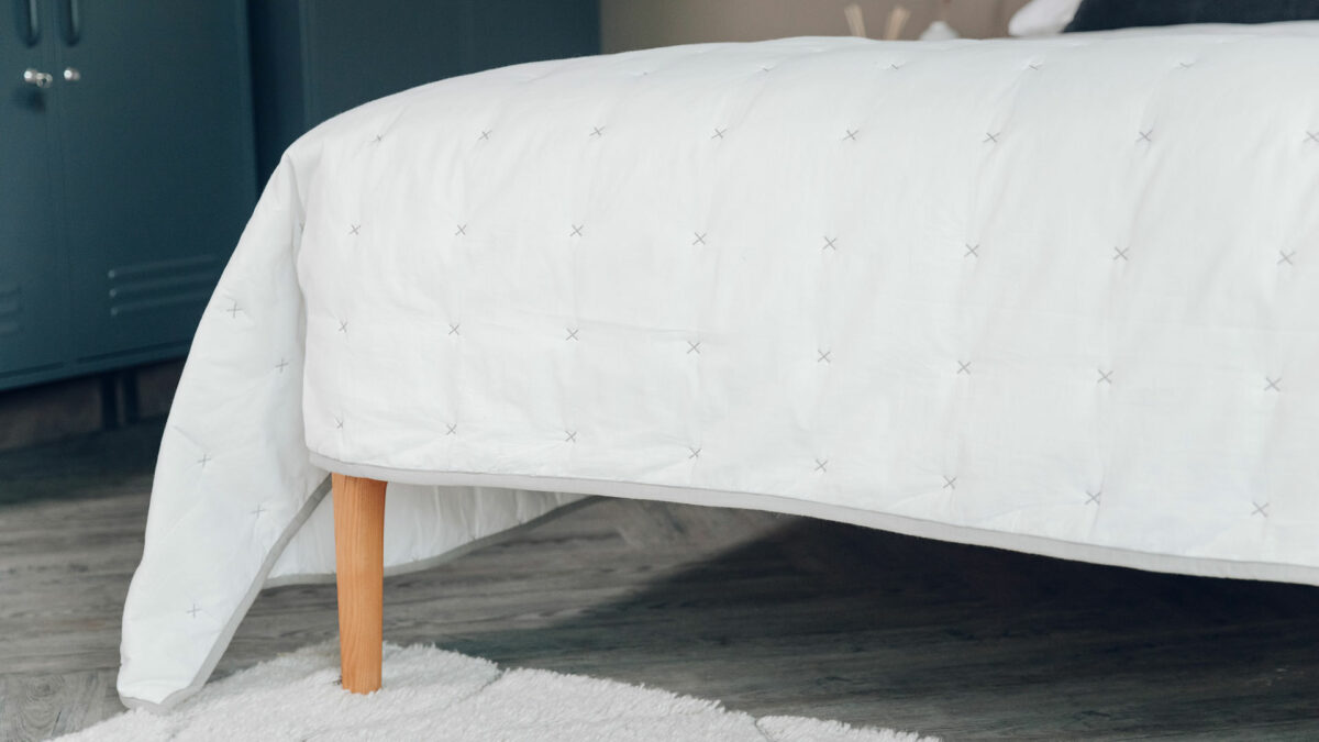 warm white quilted bedspread with grey cross stitch detail